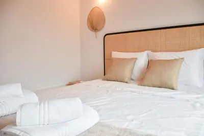 a white bed with a chair in a room at Charmosa penthouse 2 quartos - Batalha - Porto - APT N in Porto