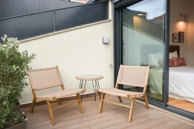 two chairs and a table on a balcony with a bed at Charmosa penthouse 2 quartos - Batalha - Porto - APT N in Porto