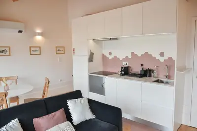 a living room with a couch and a kitchen at Charmosa penthouse 2 quartos - Batalha - Porto - APT N in Porto