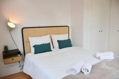 a bedroom with a white bed with towels on it at Apartamento central, junto a Praça da Batalha - APT F in Porto