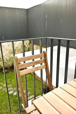a wooden chair sitting on top of a balcony at Apartamento central, junto a Praça da Batalha - APT F in Porto