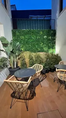 a patio with chairs and tables and a green wall at Apartamento central, junto a Praça da Batalha - APT F in Porto