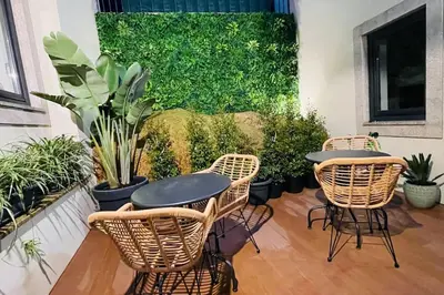 a patio with two tables and chairs and plants at Lindo apartamento em zona central, Batalha - Porto - APT L in Porto