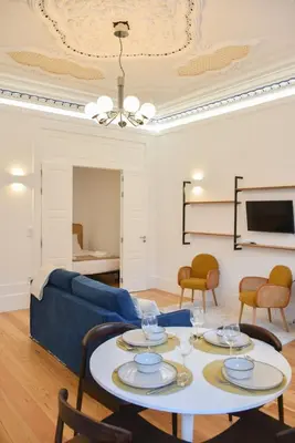 a living room with a blue couch and a table at Apartamento encantador na Batalha - Porto - APT E in Porto