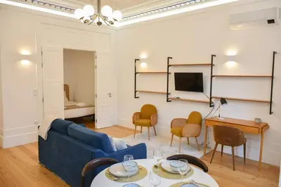 a living room with a blue couch and chairs at Apartamento encantador na Batalha - Porto - APT E in Porto