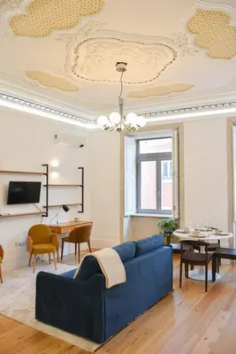 a living room with a blue couch and a table at Apartamento encantador na Batalha - Porto - APT E in Porto