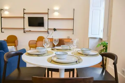 a table with plates and wine glasses on it at Apartamento encantador na Batalha - Porto - APT E in Porto