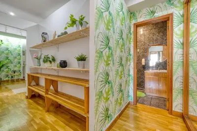 a home office with a desk and a wall with tropical wallpaper at Travel & Live Nature in Porto