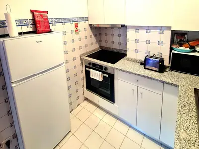 a kitchen with white cabinets and a white refrigerator at OHH - Dom Manuel - Central Lounge Apartment in Porto