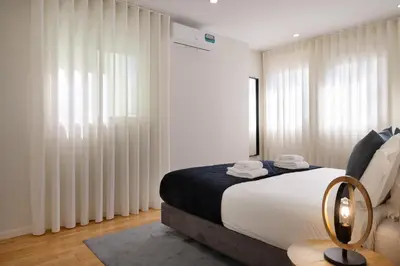 a white bathroom with a sink and a toilet at Invicta Premium - 4BR Downtown apartment with AC in Porto