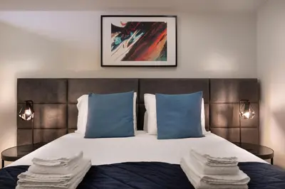 a bedroom with a large bed with blue pillows at Invicta Premium - 4BR Downtown apartment with AC in Porto