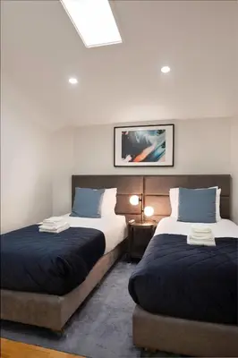 a bedroom with two beds and a table with a lamp at Invicta Premium - 4BR Downtown apartment with AC in Porto