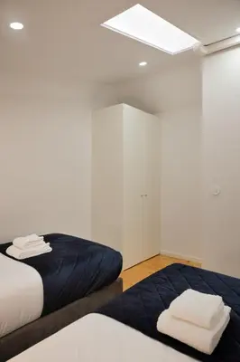 a bedroom with two beds and a skylight at Invicta Premium - 4BR Downtown apartment with AC in Porto