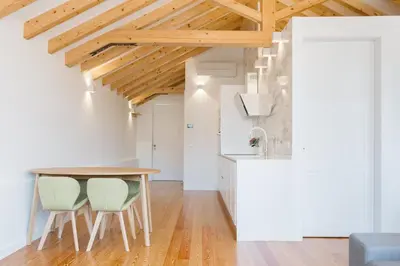 a kitchen and dining room with a wooden table and chairs at ORM Prado Apartment in Porto