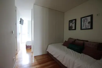 a small bedroom with a bed and a mirror at OPORTO GUEST Natária Flats with Parking in Porto