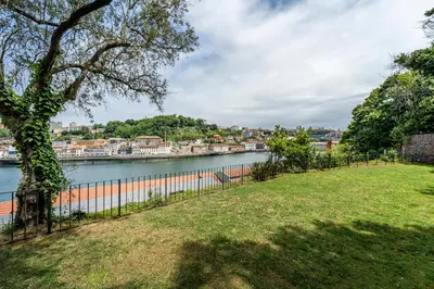 a park with a fence next to a river at Art Douro Historic Distillery in Vila Nova de Gaia