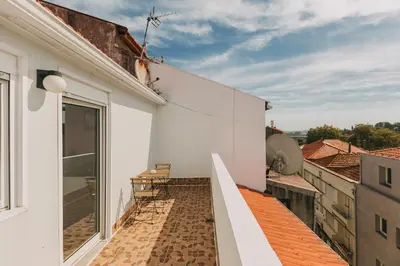 a balcony with chairs on the roof of a building at Oporto Maison Sol in Porto