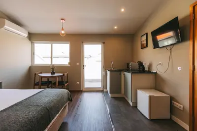 a bedroom with a bed and a kitchen with a table at Oporto Maison Sol in Porto