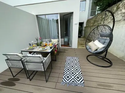 a patio with a table and a chair on a deck at Luxury in the Art District by Innkeeper in Porto