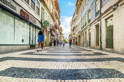 a woman walking down a cobblestone street at Luxury in the Art District by Innkeeper in Porto