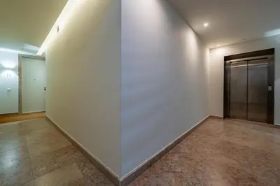 an empty room with a large white wall and a door at L'atelier L - Quartier des Arts in Porto
