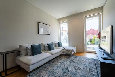 a living room with a couch and a television at L'atelier L - Quartier des Arts in Porto