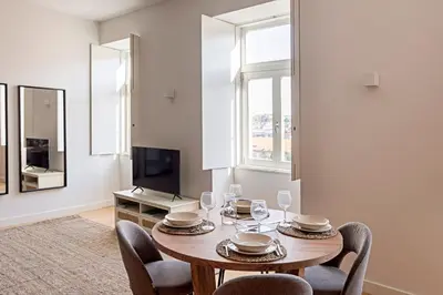 a dining room with a table and chairs and a television at Monte dos Judeus 26 by LovelyStay in Porto