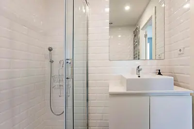 a white bathroom with a sink and a shower at Monte dos Judeus 26 by LovelyStay in Porto