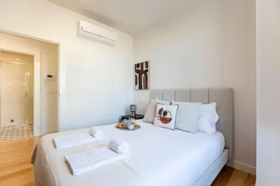 a white bedroom with a large white bed with two towels at Monte dos Judeus 26 by LovelyStay in Porto