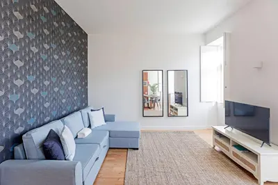 a living room with a blue couch and a tv at Monte dos Judeus 26 by LovelyStay in Porto