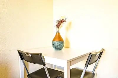 a table with a vase on it with two chairs at Porto Central Home in Porto