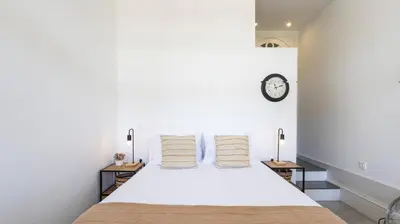 a bedroom with a large white bed with two tables at OPOrto Downtown Studio by LovelyStay in Porto