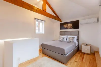 a bedroom with a bed in a white room at Villa Apartments & Suites in Porto