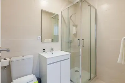 a bathroom with a shower and a toilet and a sink at Villa Apartments & Suites in Porto
