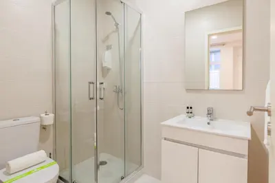 a bathroom with a shower and a toilet and a sink at Villa Apartments & Suites in Porto