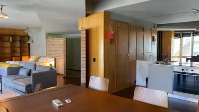 a kitchen and living room with a table and a couch at BEST - Studio Porto Downtown with AC and Parking in Porto