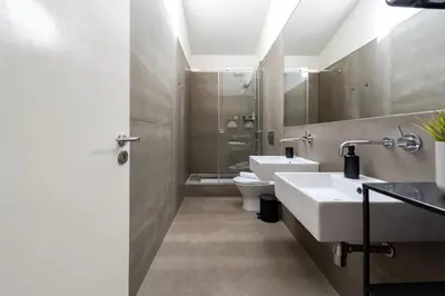 a bathroom with two sinks and a toilet at The Mouzinho Penthouse in Porto