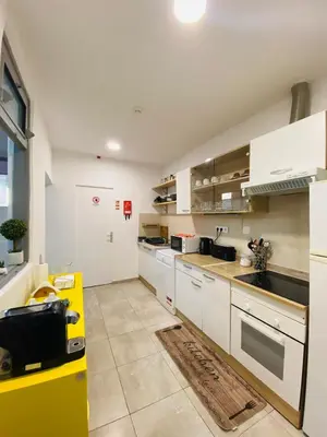 a kitchen with white cabinets and a yellow counter top at Douro sunset lounge in Porto