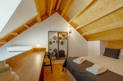 a attic room with a bed and a mirror at Elegant Downtown Apartment by Vacationy in Porto