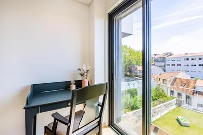 a dining room and living room with a large window at Camões Downtown with Parking in Porto