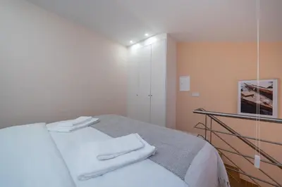 a white room with a bed with white towels on it at Paraíso Apartment by Amber Star Rent in Porto