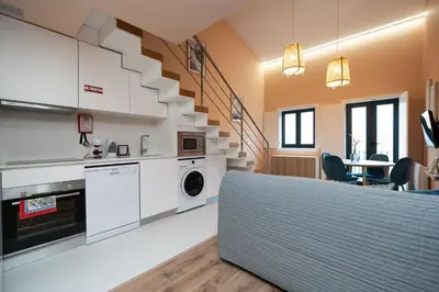 a kitchen with white cabinets and a staircase at Paraíso Apartment by Amber Star Rent in Porto