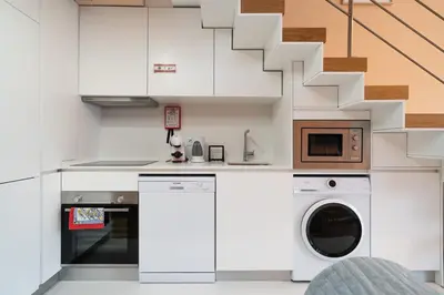 a kitchen with white cabinets and a washer and dryer at Paraíso Apartment by Amber Star Rent in Porto