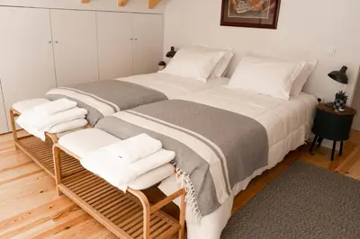 two beds in a room with two white chairs at Casa Girasol River View in Porto