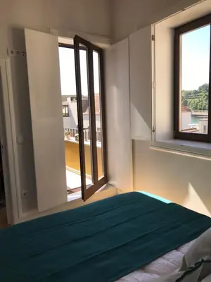 a bedroom with a bed and two windows at Casa Girasol River View in Porto