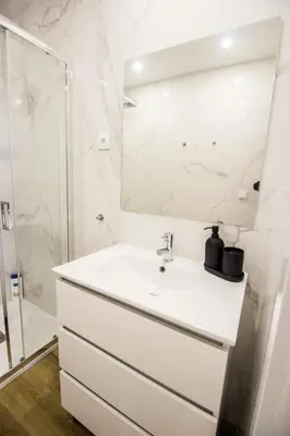 a white bathroom with a sink and a mirror at Guest H4U - Porto Bonfim Heroismo in Porto