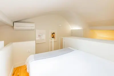 a bedroom with a large white bed in a room at Oporto Loft with Mezzanine in Porto