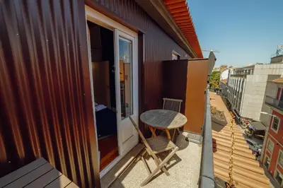 a small balcony with a table and a window at Downtown Prime With Terrace by Vacationy in Porto