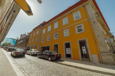 an orange building with cars parked on a street at Downtown Prime With Terrace by Vacationy in Porto