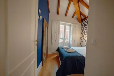 a bedroom with a bed with a blue wall at Downtown Prime With Terrace by Vacationy in Porto